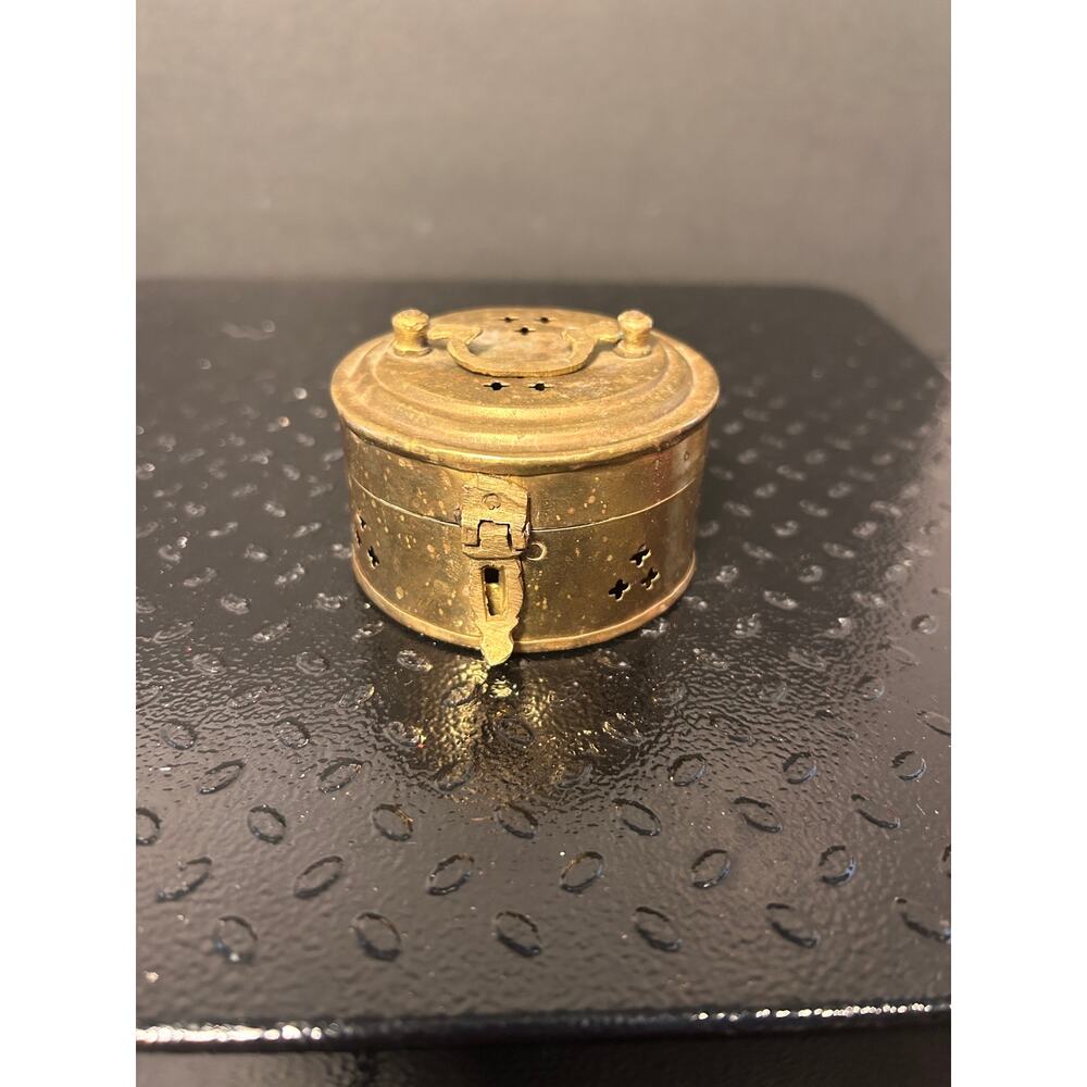 vintage brass cricket box, with ventilation holes and small carrying handle.